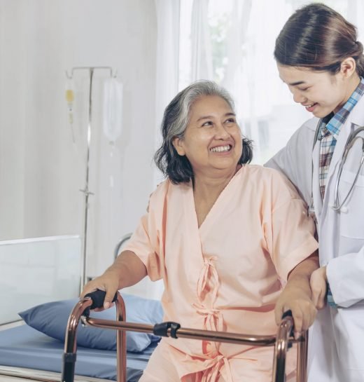 elderly-female-smiling-with-young-female-doctor-visiting-senior-patient-woman-hospital-ward-min